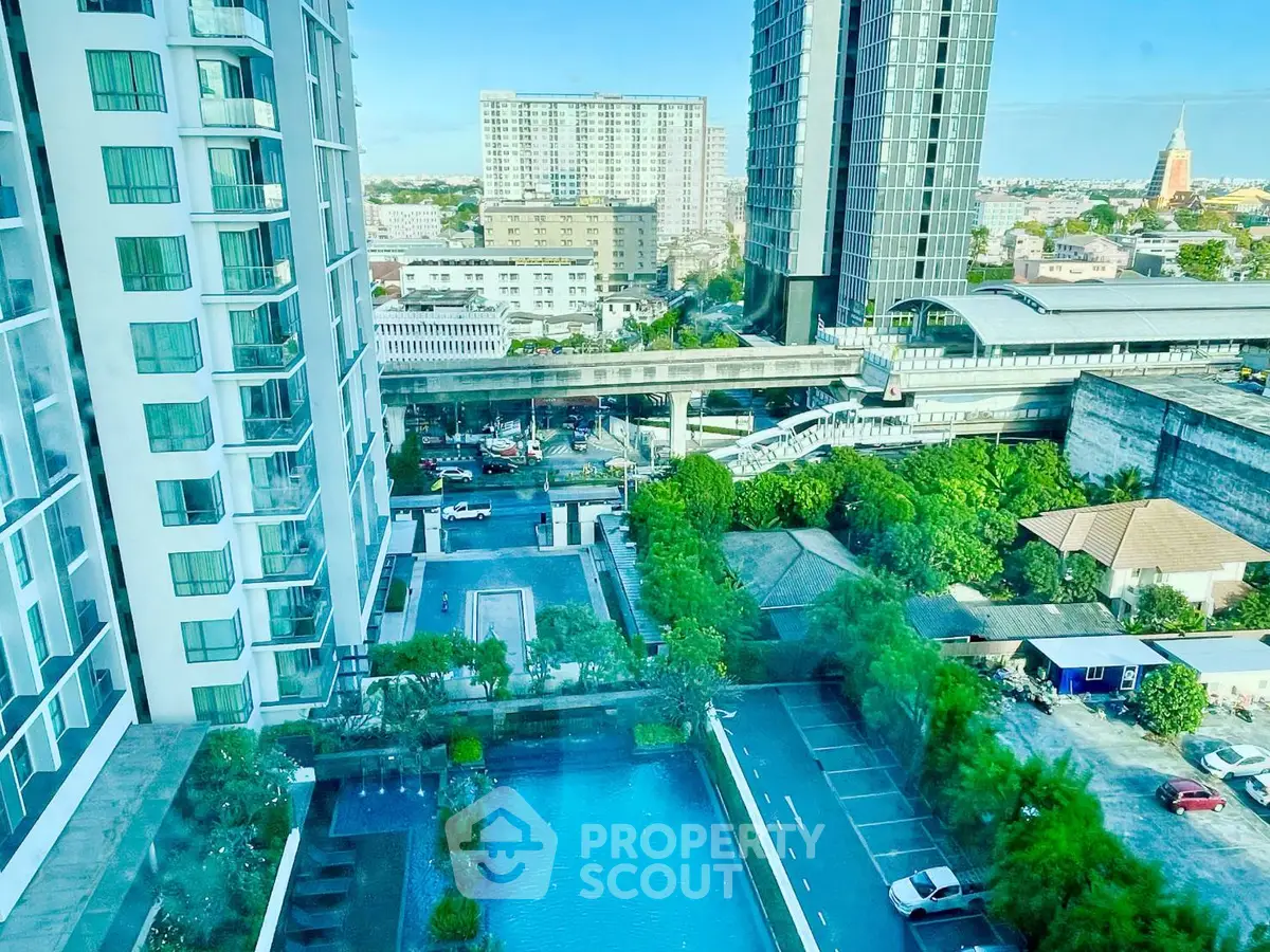 Stunning urban view from high-rise apartment with pool and parking area.