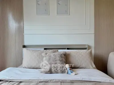 Cozy bedroom with plush pillows and a soft toy on the bed, perfect for relaxation.