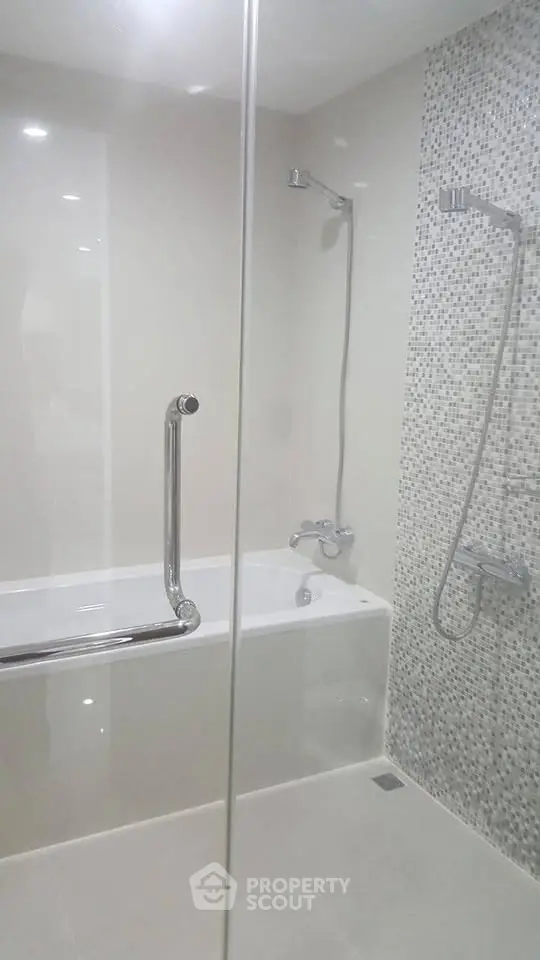 Modern bathroom with sleek design featuring a bathtub and stylish shower fixtures.