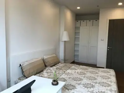 Modern bedroom with stylish decor and ample storage space in a cozy apartment.