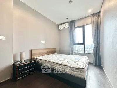 Modern bedroom with city view, featuring a comfortable bed and sleek design.