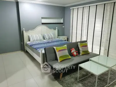 Spacious bedroom with stylish decor and cozy seating area, perfect for relaxation and comfort.