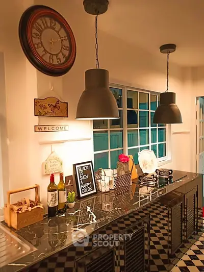 Charming kitchen with modern lighting and stylish decor, featuring a sleek countertop and checkerboard flooring.