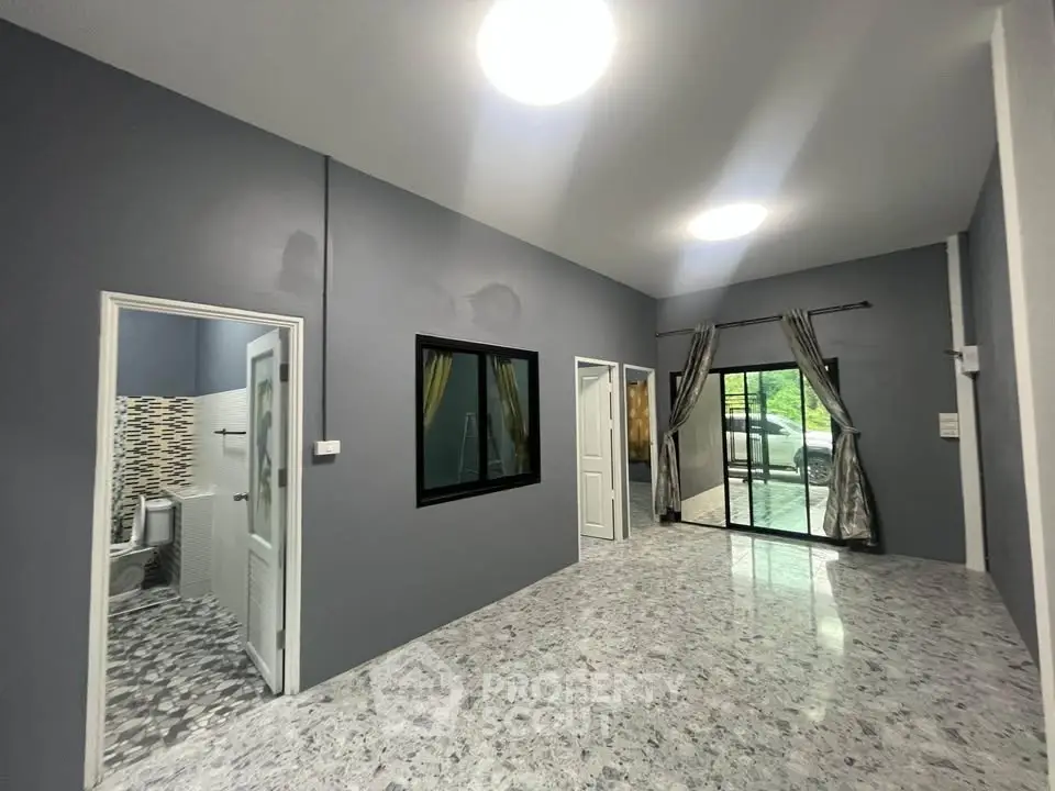 Spacious modern living room with large windows and marble flooring