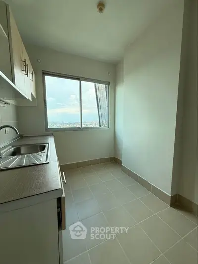 Compact kitchen with large window offering panoramic city views.