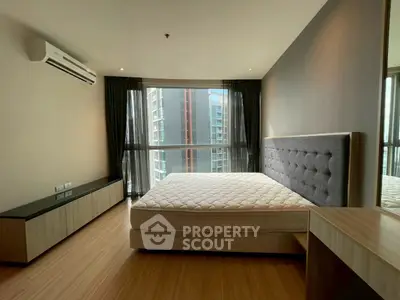 Modern bedroom with large window and stylish decor in urban apartment