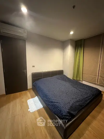 Modern bedroom with wooden flooring and stylish bed in cozy apartment