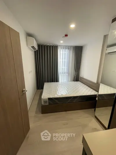 Modern bedroom with natural light, featuring a comfortable bed and stylish curtains, perfect for relaxation.