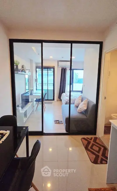 Modern living room with glass partition and stylish decor in a cozy apartment.