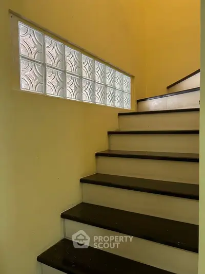 Charming staircase with glass block window in cozy home interior
