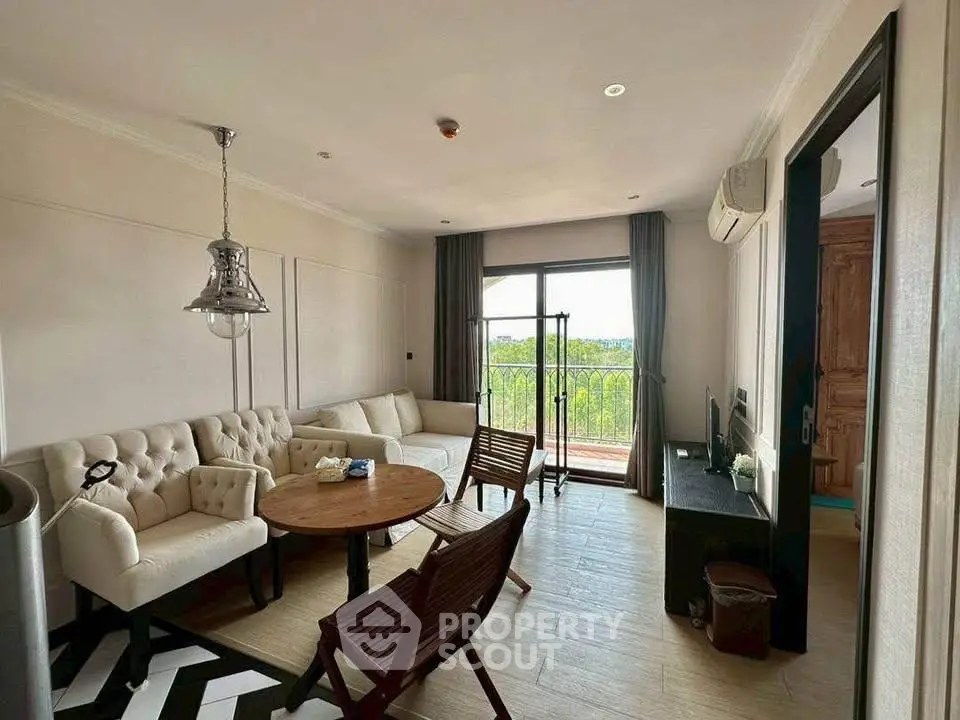 Charming living room with elegant furniture and balcony view, perfect for relaxation and entertaining.