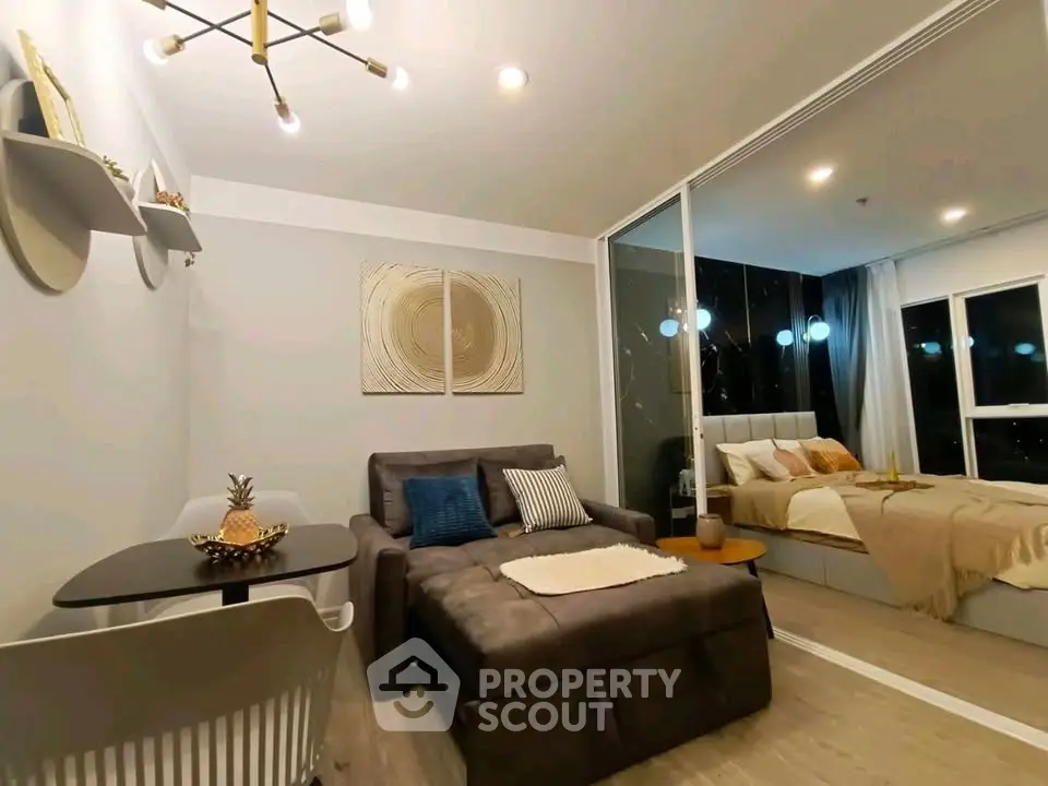 Modern living room with cozy seating and stylish decor adjacent to a chic bedroom.