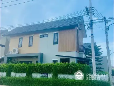 Modern two-story house with a stylish facade and lush greenery, perfect for family living in a serene neighborhood.