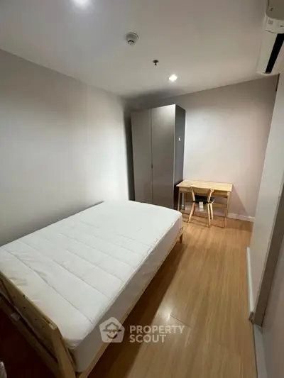 Cozy minimalist bedroom with wooden flooring and modern furniture