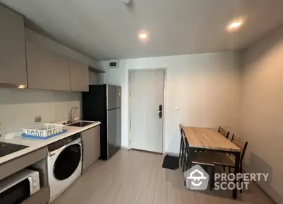 Modern kitchen with dining area, featuring sleek appliances and minimalist design.