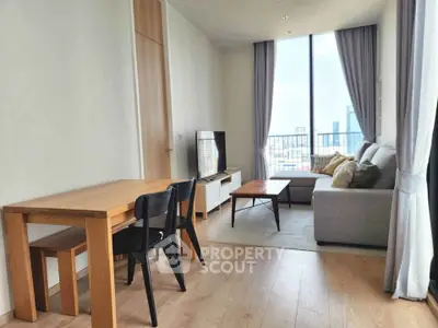 Modern living room with city view, featuring sleek furniture and large windows for natural light.