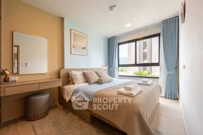 Modern bedroom with large window and stylish decor in a cozy apartment.