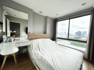 Modern bedroom with large window offering stunning city view