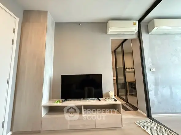 Modern living room with sleek TV stand and air conditioning in a stylish apartment.