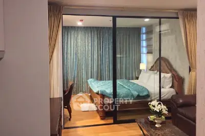Luxurious bedroom with elegant decor and glass partition in modern apartment.