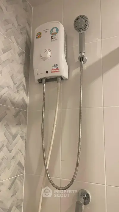 Modern bathroom with sleek electric shower unit and stylish tile design.