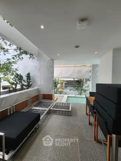 Modern balcony with stylish seating and pool view in luxury apartment