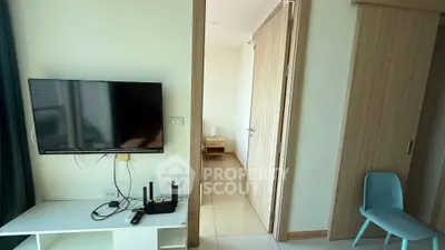 Modern living room with wall-mounted TV and minimalist decor in a bright apartment.
