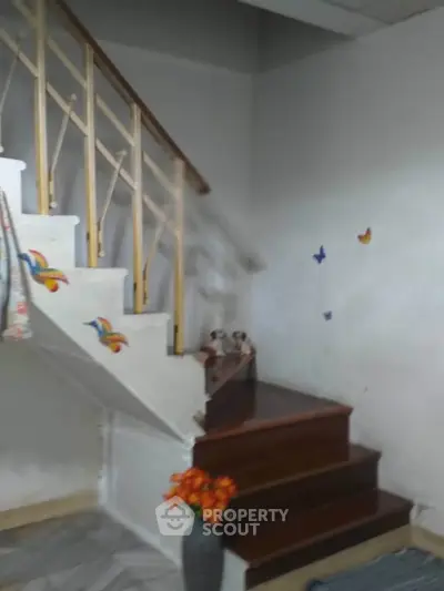 Charming staircase with wooden steps and decorative wall accents in cozy home interior.