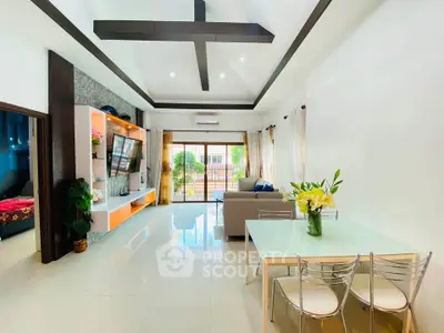 Spacious modern living room with high ceilings and elegant decor, featuring a cozy seating area and dining space.
