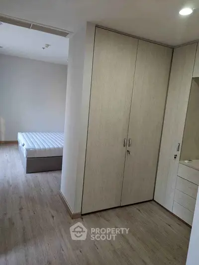 Spacious bedroom with modern wardrobe and natural light, perfect for comfortable living.