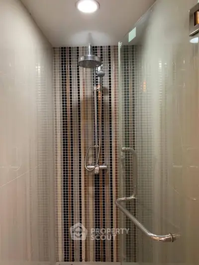 Modern shower with sleek tile design and chrome fixtures in a contemporary bathroom.