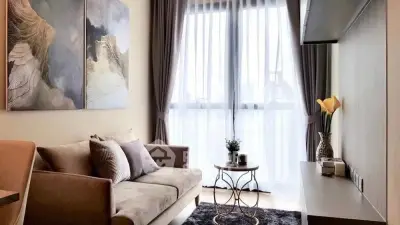 Stylish living room with modern decor and large window, perfect for relaxation.