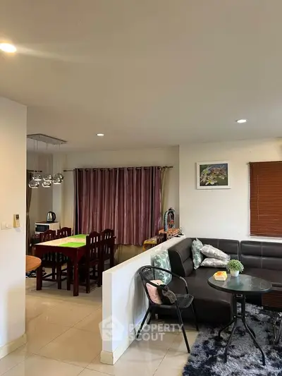 Spacious living room with modern decor and dining area, perfect for family gatherings.