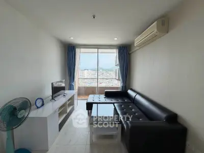 Modern living room with city view, sleek black sofa, and air conditioning in a high-rise apartment.