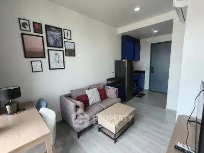 Modern living room with stylish decor and compact kitchen in open layout apartment.