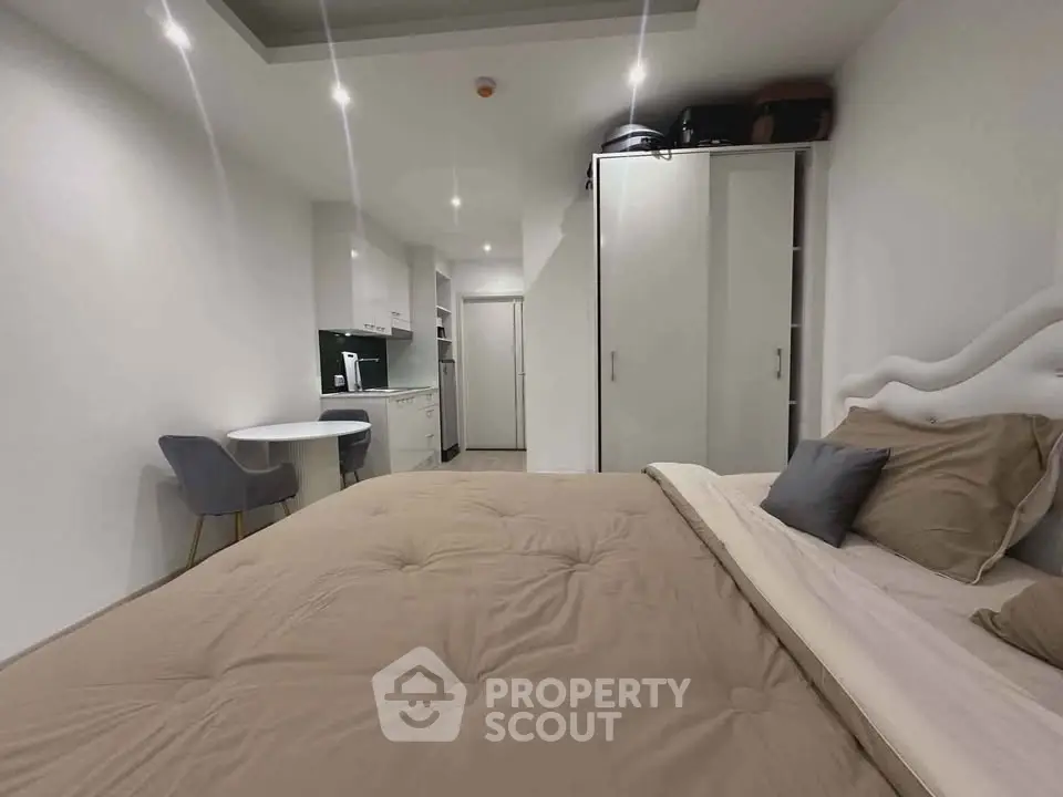 Modern studio apartment with cozy bedroom and compact kitchen area.