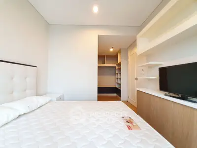 Modern bedroom with built-in shelves and TV, featuring a comfortable bed and minimalist design.
