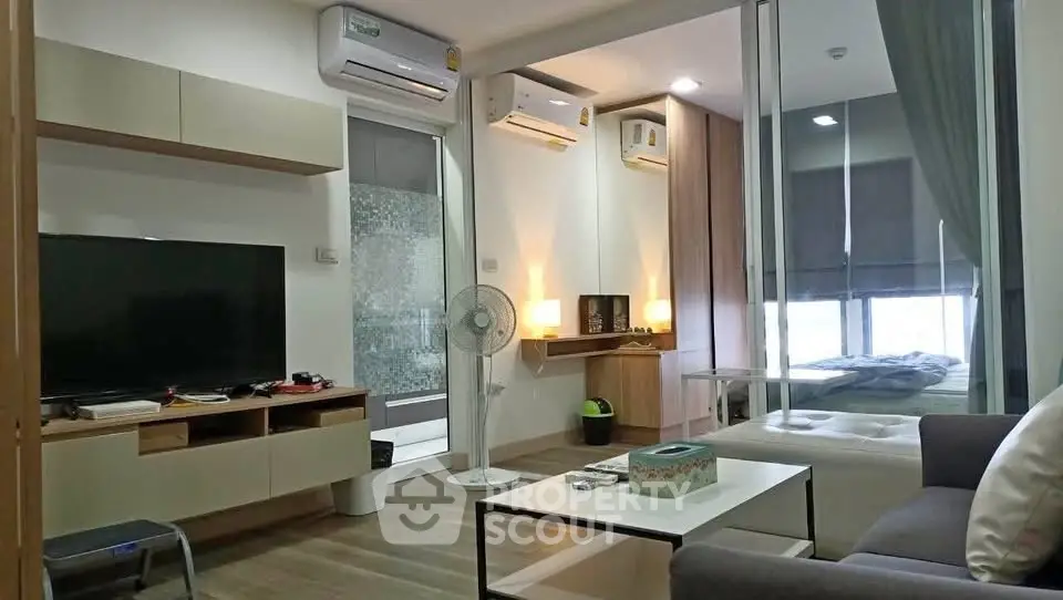 Modern living room with sleek design and cozy bedroom view in a stylish apartment.