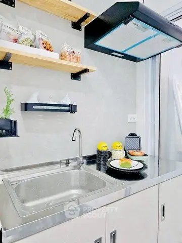 Modern kitchen with sleek stainless steel sink and open shelving