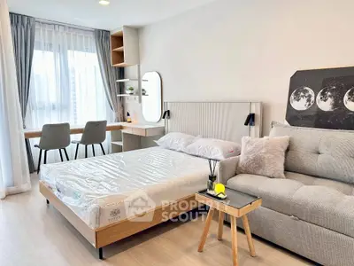 Modern bedroom with cozy seating and workspace, featuring stylish decor and natural light.