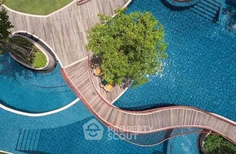 Stunning aerial view of a luxurious pool with elegant wooden walkways and lush greenery.