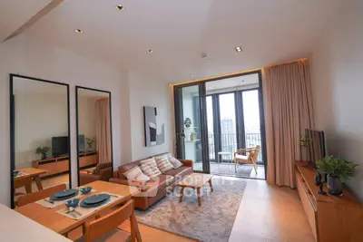 Modern living room with balcony view, stylish furniture, and natural light.