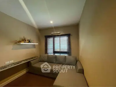 Cozy living room with modern sofa and wall shelf in a well-lit space.