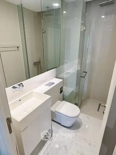 Modern bathroom with glass shower and sleek fixtures in a contemporary apartment.