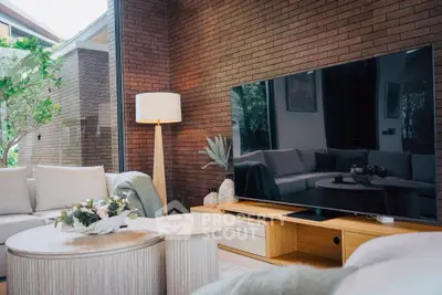 Luxurious living room with modern decor and large flat-screen TV, perfect for relaxation and entertainment.