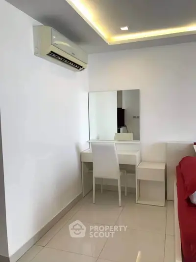 Modern bedroom corner with sleek white furniture and air conditioning unit.