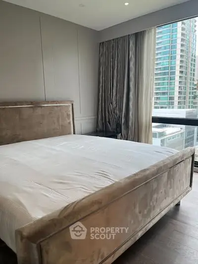 Luxurious bedroom with plush bed and city view, perfect for urban living.
