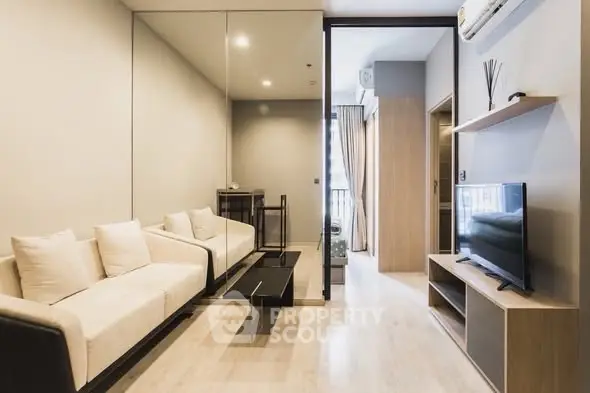 Modern living room with sleek design and natural light, featuring a cozy sofa and flat-screen TV.