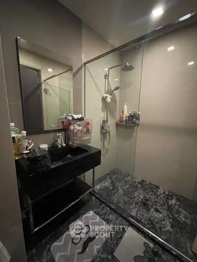 Modern bathroom with glass shower and sleek black vanity
