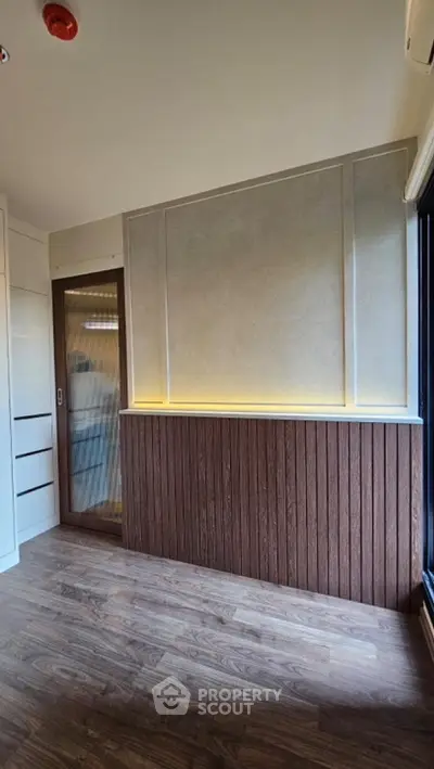 Modern interior with wood paneling and sliding door, featuring ambient lighting.